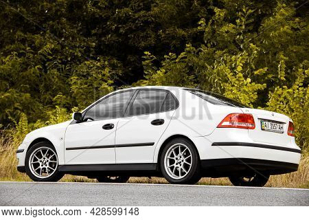 Chernigov, Ukraine - July 24, 2021: Saab Car On The Road. White Saab 9-3 Car On The Background Of Tr