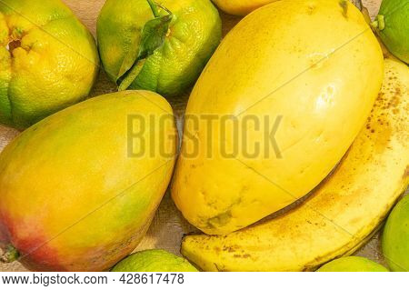 Fruits On The Table, Mango, Banana, Papaya, Tangerine And Lemon. Fruits With Predominant Yellow Tone