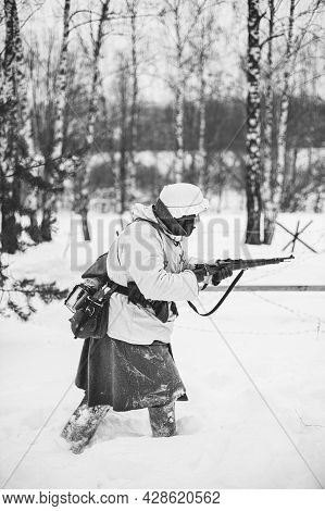 Re-enactor Dressed Like German Wehrmacht Infantry Soldier In World War Ii Attacking With Rifle In Wi