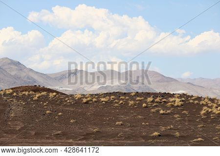 Lava Rocks On A Volcanic Crater With Barren Badlands Beyond Taken At Fossil Rocks At The Great Basin