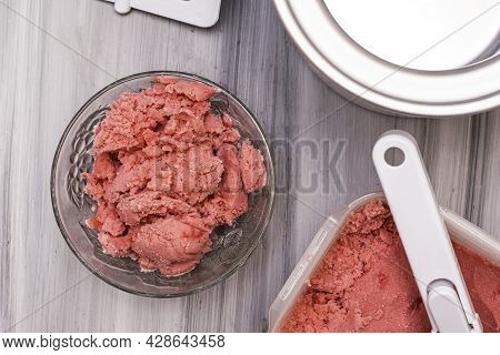 Homemade Cherry Ice Cream In A Plastic Container On The Table Next To An Ice Cream Spoon And An Ice 