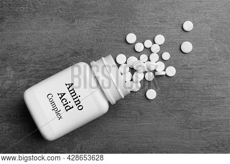 Plastic Bottle With Amino Acid Complex And Pills On Grey Background, Flat Lay