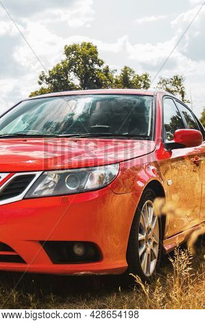 Chernigov, Ukraine - July 24, 2021: Saab Cars On The Road. Red Saab 9-3 Car On The Background Of Tre