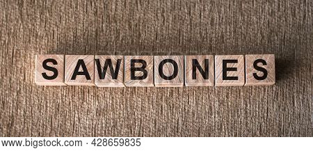 Sawbones Word Written On Wooden Blocks On A Brown Background.