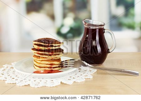 หวาน pancakes บนแผ่นกับแยมบนโต๊ะในห้องครัว