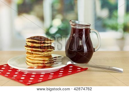 หวาน pancakes บนแผ่นกับแยมบนโต๊ะในห้องครัว