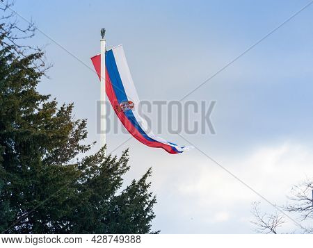 Photo Of The Official Flag Of The Republic Of Serbia, With A Backround Of Blue Sky And Clouds. Serbi