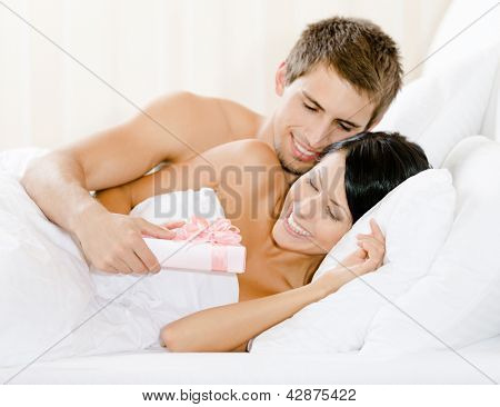 Mann liegend im Bett-Zimmer gibt heute mit Frau Rosa Papier umwickelt