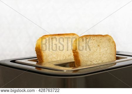 Two Crispy Toasters Are In The Toaster. Bread Slices Are Prepared For Breakfast