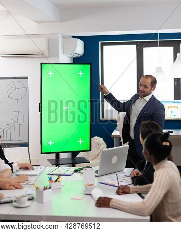Leader Of Company Presenting Financial Plan Using Mockup Display In Front Of Diverse Team Brainstorm
