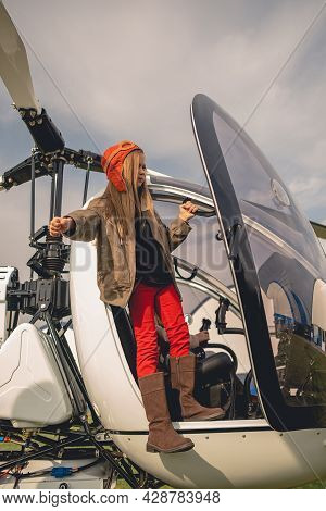 Tween Girl In Pilot Hat Looking Into Distance From Helicopter Cockpit