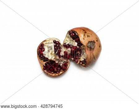 Spoiled, Unhealthy, Open Red Pomegranate With Seeds Falling Out. Concept Of Expired Food Products. C