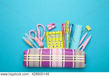 Pencil Case And School Supplies On Blue Background. Top View.