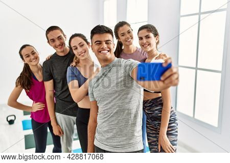 Group of young sporty people smiling happy make selfie by the smartphone at sport center.