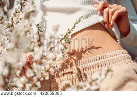 Partial View Of Beautiful Slender Woman In Delicate Clothes Posing With Hands Near Her Belly And Wit