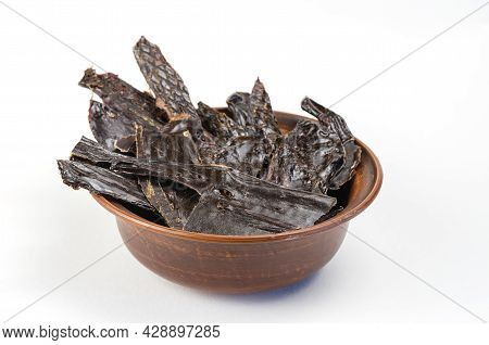 Dried Dog Treats In A Brown Clay Bowl On A White Background. Thin Slices Of Dehydrated Beef Liver. T