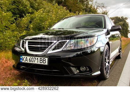 Chernigov, Ukraine - July 24, 2021: Saab Car On The Road. Black Saab 9-3 Car On The Background Of Tr