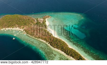 Aerial Drone Island In Blue Lagoon With Sandy Beach And Coral Reef. Malcapuya, Philippines, Palawan.