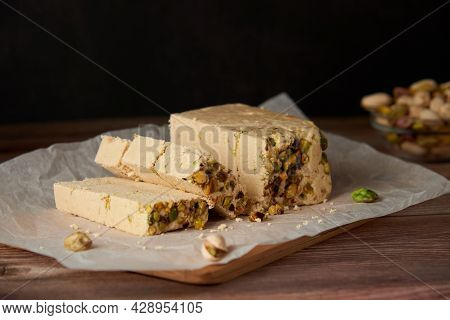Organic Halva With Pistachios On A Wooden Surface. Traditional Middle Eastern Sweets. Jewish, turkis