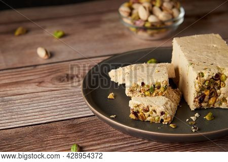 Organic Halva With Pistachios On A Wooden Surface. Traditional Middle Eastern Sweets. Jewish, turkis