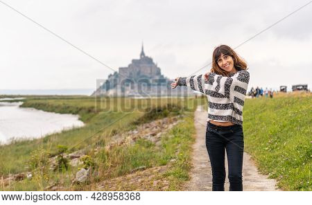 A Young Tourist Walking From Point De Vue Towards The Abbey Of Mont Saint-michel, Normandy Region, F