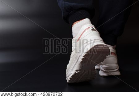 Foots Wer Sport Shoes, Close Up On Black Background With Copy Space.