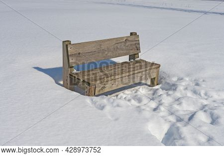 Wooden Bench In Winter Snow In Crabtree Nature Center In Illinois