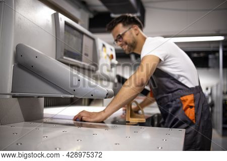Operator Working On Paper Cut Machine In Printing Factory.