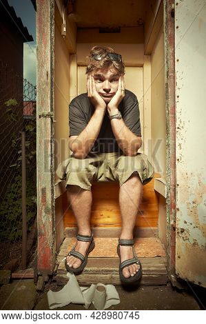 Man Using Wooden Toilet Latrine On Summer Cottage