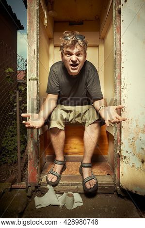 Man Using Wooden Toilet Latrine On Summer Cottage