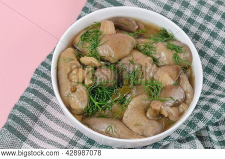 Marinated Mushrooms In A White Ceramic Bowl With Dill. Ready To Eat Suillus. Traditional Ukrainian A