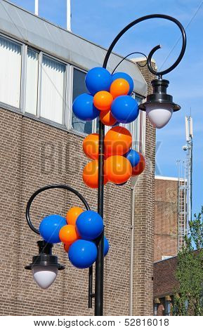 Colourful Balloons Adorn The Column With Lantern On A City Stree