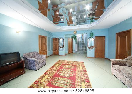 Hallway with chair, sofa, carpet on the floor and five doors
