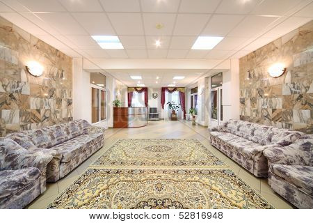 Spacious light hall with sofas and the reception in a holiday home