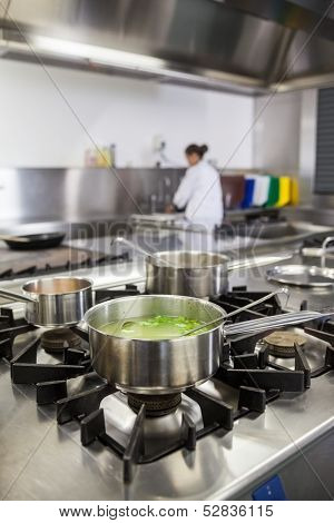 Several pots cooking on hotplate in professional kitchen