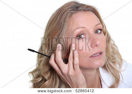 Woman applying mascara