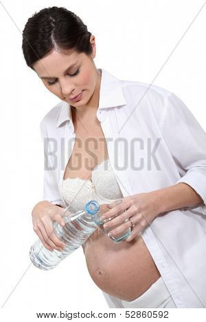 Pregnant woman holding bottle of water