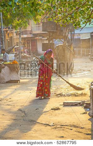 Indian Women Of Fourt Class In Brightly Colored Clothing Cleans The Street