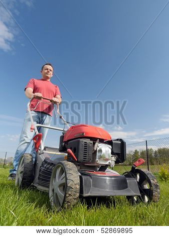 Man mowing grass with grass-mower 