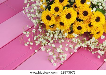 Beautiful flowers on wooden background
