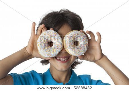  Little boy making fun with donuts on white background,