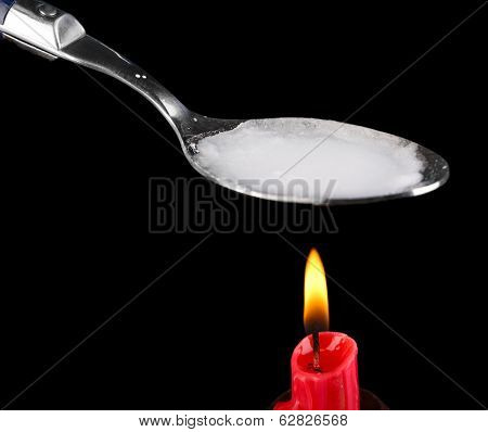 Heroin in spoon on black background