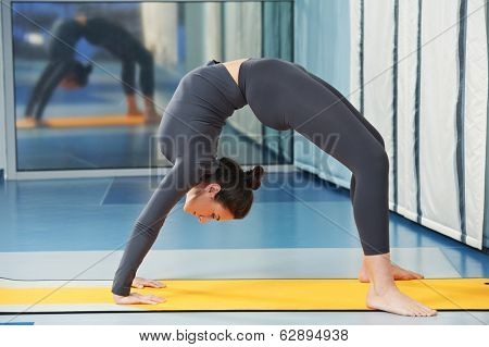 Happy smiling woman at gymnastic physical training fitness exercise in gym
