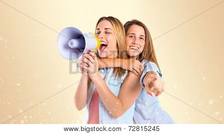 Girls Shouting With Megaphone Over Ocher Background