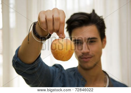 Young Man Holding A Large Delicious Ripe Apple
