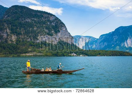 People Crossing The Lake With A Traditional Boat
