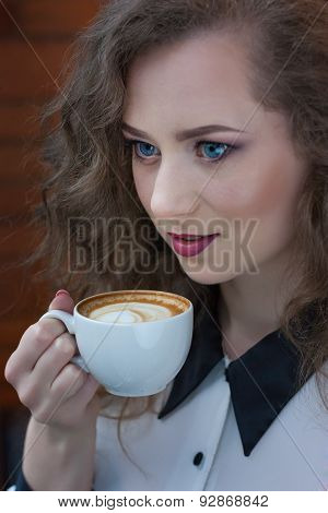 Close Up Portrait Of Beautiful Girl With Coffee In A White Shirt At The Window.