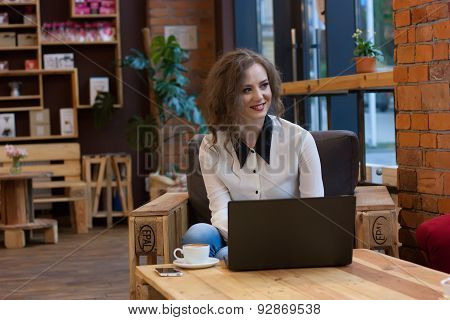 Friendly Girl Working On A Laptop In A Cafe