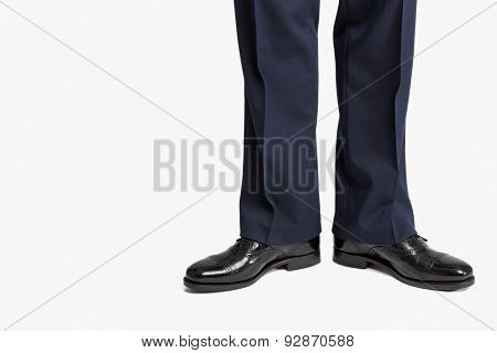 Man In Stylish Black Shiny Male Semi-brogue Posing In Direct Position Against White.