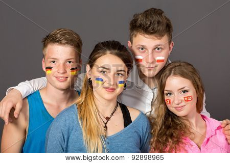 Four teenagers with flags drawn on the faces